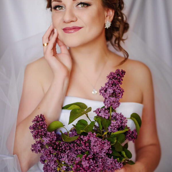Portret panny młodej z bukietem kwiatów w dłoniach