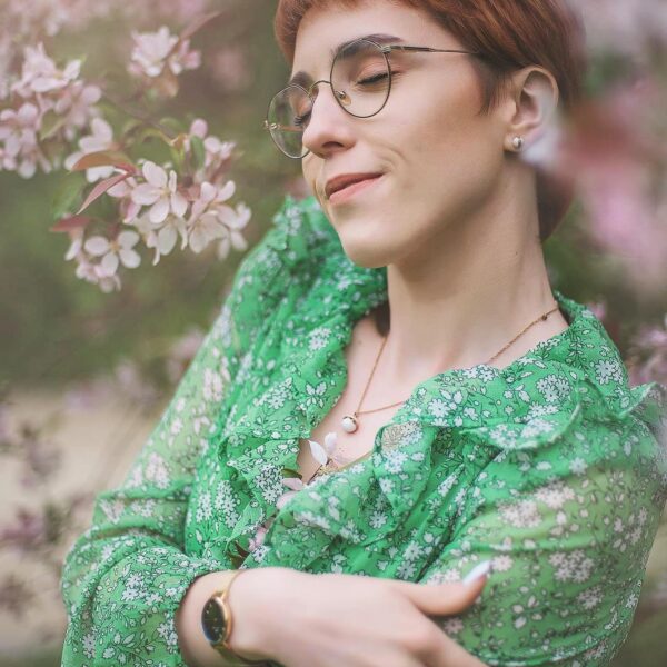 wiosenny portret kobiety w zielonej sukience z okularami w różowym kwiatku- portret w naturze Lubartów – sesja zdjęciowa
