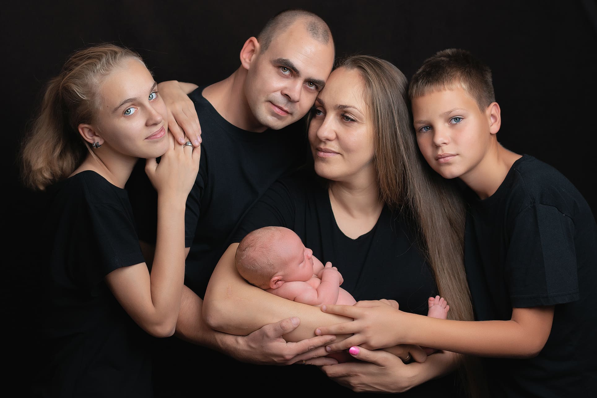 Rodzinne zdjęcie z noworodkiem w ramionach rodziny