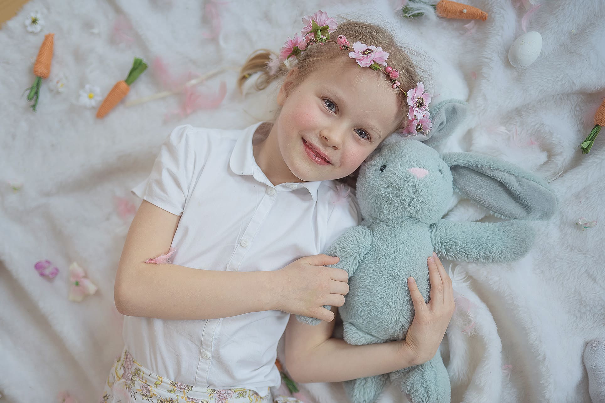 Uśmiechnięte dziecko podczas sesji fotograficznej w studiu dziewczyna z królikiem